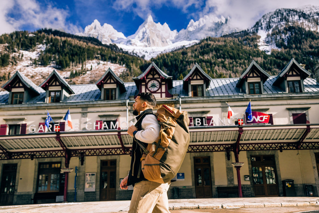 A man carries a duffel bag on his back through Chamonix